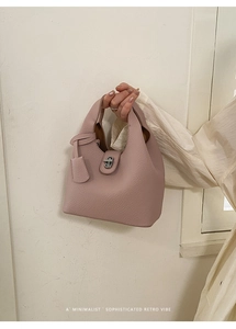 Macro detail of dusky pink lychee grain leather bucket bag with silver metal lock