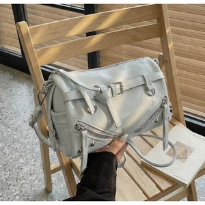 Detail of light green motorcycle boston bag with silver hardware and glossy leather