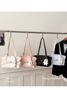 Row of minimalist commuter tote bags in four colors with cute teddy bear pendants