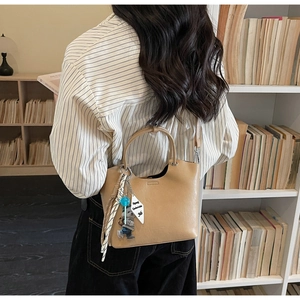 Détail du sac seau camel avec texture cuir souple et charms mignons en décor de style de vie