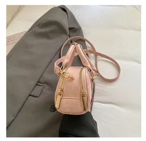 Dettaglio borsa Boston rosa con trama a grana e cerniere in metallo dorato lucido