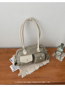 Detail view of military green canvas bag with light beige utility pockets and long handles