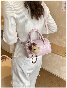 Close-up of pink Boston pillow bag with cute teddy bear charm and silver hardware detail