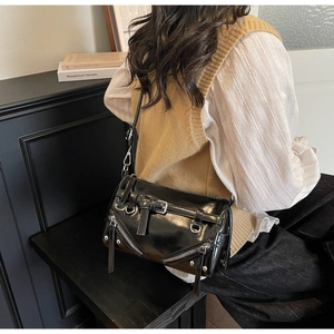 Detail of a black punk-style bowling bag with silver metal studs and zipper hardware