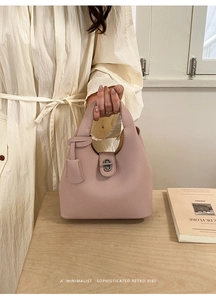 Detailed macro of dusty pink leather bucket bag with silver twist lock and pebble texture