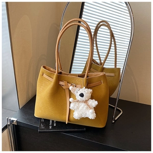 Detail of ginger woven tote bag texture with cute plush bear charm on round handle
