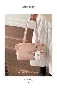 Pink faux leather tote bag detail with decorative belt buckle and white plush puppy charm