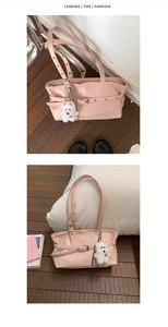 Detail view of pink leather tote bag with belt buckle decor and plush dog charm
