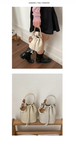 Detailed view of two minimalist drawstring bucket bags in white and beige litchi leather