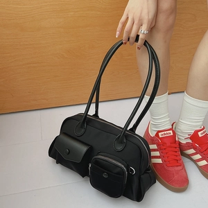 Minimalist black nylon shoulder bag with dual exterior pockets and versatile crossbody strap