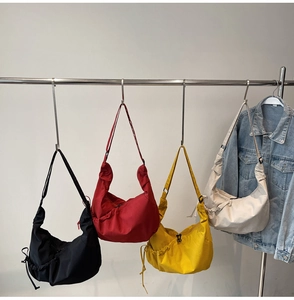 Detail of colorful nylon dumpling bags with drawstring side design on metal hangers