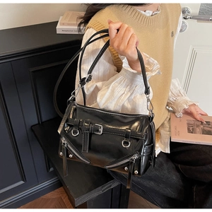 Detail of black glossy bowling bag with silver zipper accents and chic motorcycle style