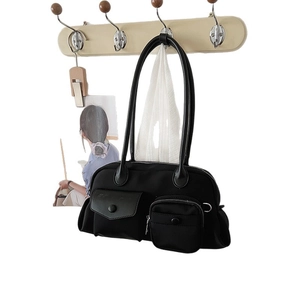 Modern black nylon crossbody bag with dual utility front pockets and wide shoulder strap