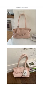 Detail of light pink tote bag with textured finish and cute white plush dog charm