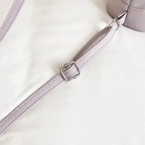 Détail de la sangle réglable avec boucle en métal argenté sur un sac mode lavande