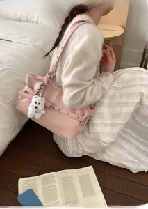Pink faux leather tote bag with silver eyelets and a cute plush dog pendant detail
