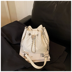 Detail shot of white quilted leather bucket bag with silver chain and elegant texture