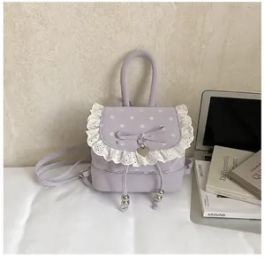 Gros plan du sac à dos lavande à pois avec bordure en dentelle et pendentif cœur