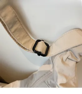 Detail view of the adjustable black buckle on the off-white dumpling bag strap