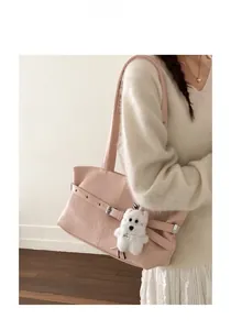 Pink faux leather tote bag with decorative buckle and a white plush puppy keychain detail