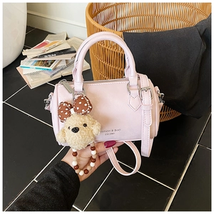 Close-up of pink Boston bag with dog charm, beads, and Fashion & BAG branding details