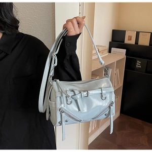Detail of light blue faux leather Boston bag featuring silver hardware and decorative zippers