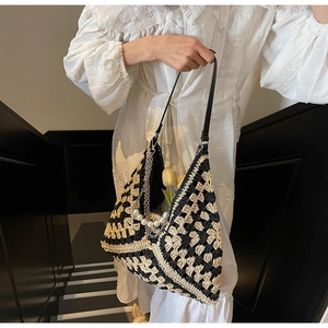 Dettaglio della borsa tote in paglia intrecciata a scacchi con catena di perle e tracolla