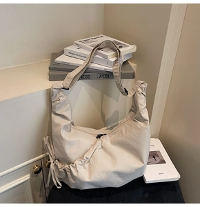 Detail of off-white oversized hobo bag featuring drawstring pleats and wide shoulder strap
