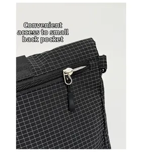 Vue détaillée de la poche arrière sur un sac à carreaux étanche avec fermeture éclair