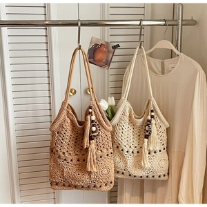 Close-up of hollow woven cotton beach bag with wooden beads and long tassel charm
