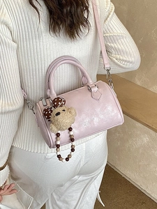 Pink Boston style handbag with top handles and a cute plush bear charm for daily use