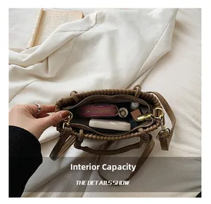 Macro view of brown pleated bag interior showing large capacity for phone and wallet
