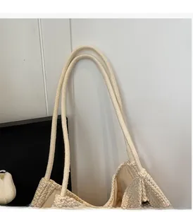 Detailed macro view of sturdy double round braided handles on a beige woven beach bag