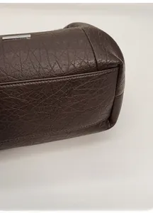Détail macro du fond de sac cabas en cuir marron avec motif grainé et coutures renforcées