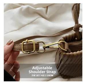 Close-up of adjustable shoulder strap and gold hardware on brown leather bag