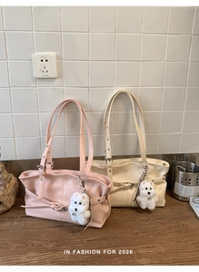 Detail of pink and beige leather tote bags with cute plush charms and fashion straps