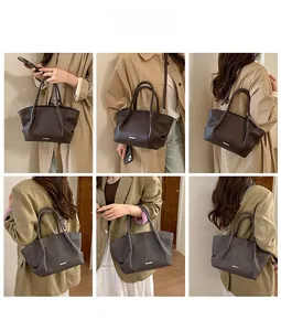 Détail du sac cabas en cuir marron foncé avec logo métallique et bandoulière amovible