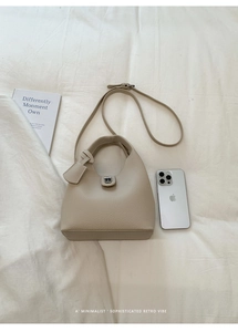 Detailed macro view of beige lychee texture leather with elegant silver twist lock hardware