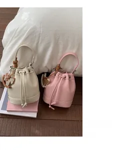 Detail of lychee pattern bucket bags with decorative cord handle and wooden horse charm