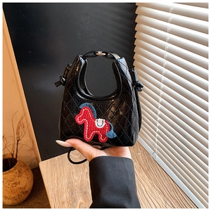 Close-up of quilted black mini bag featuring horse embroidery and silver hardware clasp