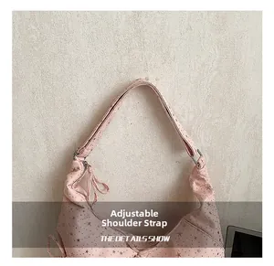 Detail showing the adjustable shoulder strap and star pattern on pink bag