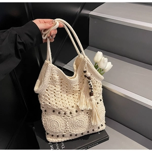 Detailed texture of ivory crochet tote bag with wooden beads and long tassel fringe