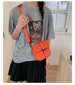 Détail du sac bandoulière orange à carreaux avec boucle et sangle ajustable