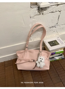 Pink faux leather tote bag with pleated design and a cute white plush puppy charm