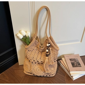 Close-up of hollow crochet knit bag featuring wood beads and long fringe tassels