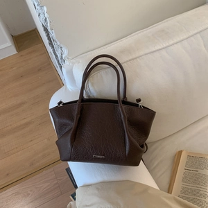 Détail du sac cabas marron foncé à motif litchi avec doubles poignées et logo en métal