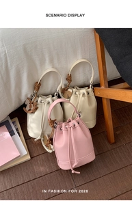 Pink and beige drawstring bucket bags in lychee leather featuring a horse charm detail