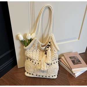 Detail of hollow woven cotton beach bag with wooden beads, tassels and tulip decor