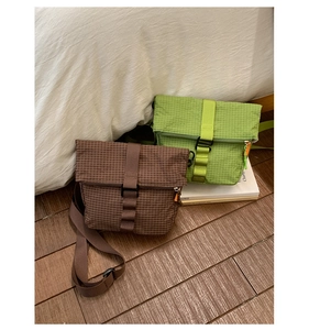 Détail de la texture à carreaux imperméable et de la bandoulière des sacs bandoulière