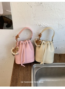 Litchi pattern leather bucket bags in pink and beige with decorative rocking horse pendant